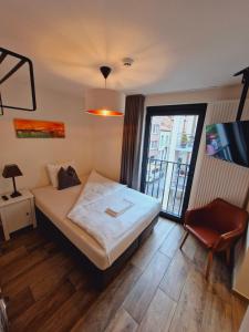 a small bedroom with a bed and a window at Hotel Ladeuze in Leuven