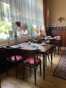 un restaurante con mesas y sillas de madera y una gran ventana en Hotel Krone, en Arnstadt