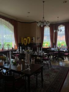 un comedor con mesas, sillas y ventanas en Hotel Krone, en Arnstadt