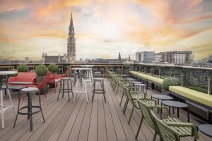 d'un balcon avec des tables et des chaises offrant une vue sur la ville. dans l'établissement Warwick Brussels - Grand Place, à Bruxelles