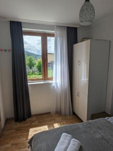 een slaapkamer met een groot raam en een bed van 1 m2 bij Apartment in Mestia in Mestia