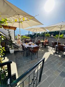 un patio avec des tables, des chaises et des parasols dans l'établissement Kore Guest House, à Gjirokastër