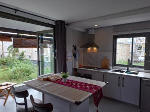 a kitchen with a table and a large window at Luxury Apartment 150 m from the beach in Flic-en-Flac