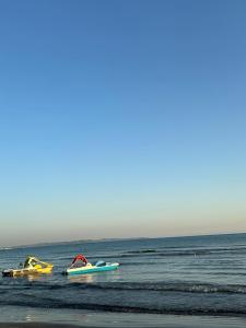 drie boten in het water op een strand bij Durres Apartment in Durrës