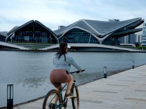 珠海市にあるZhuhai Marriott Hotel Jinwanの建物前の自転車乗り女