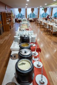 uma longa mesa cheia de pratos e tigelas de comida em Hotel Barátság em Hajdúszoboszló