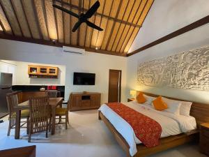 1 dormitorio con 1 cama y comedor en Bali Santi Bungalows, en Candidasa