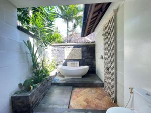 - Baño con bañera en el patio en Bali Santi Bungalows, en Candidasa