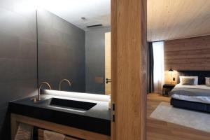 アンデルマットにあるAndermatt Alpine Apartmentsのバスルーム(シンク、ベッド付)