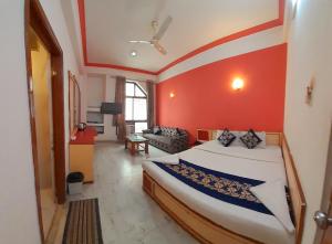 een slaapkamer met een bed met een rode muur bij Hotel Indore Palace - Guest Centric Hotel in Shirdi