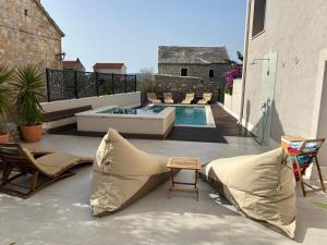 une terrasse avec une piscine, des chaises et une table dans l'établissement Bol Summer Residence, à Bol