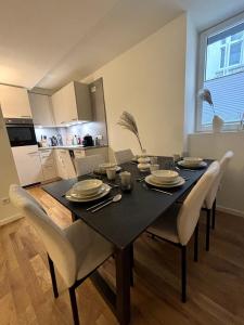 uma mesa de jantar e cadeiras com uma mesa preta e uma cozinha em City Apartment am Fluss em Frankfurt am Main