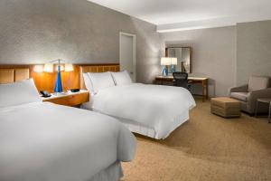 a hotel room with two beds and a chair at The Westin Chicago Northwest in Itasca