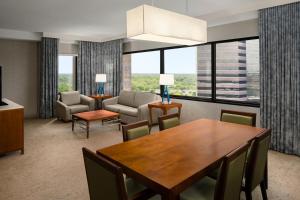 a dining room with a table and chairs and a couch at The Westin Chicago Northwest in Itasca