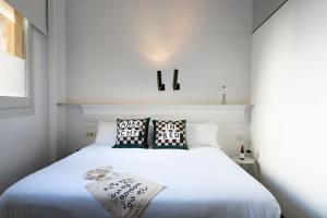 - une chambre blanche avec un lit blanc et 2 oreillers dans l'établissement Chic & Basic Born Boutique Hotel, à Barcelone