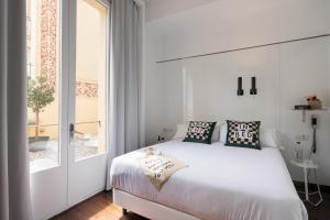 - une chambre blanche avec un lit et une fenêtre dans l'établissement Chic & Basic Born Boutique Hotel, à Barcelone