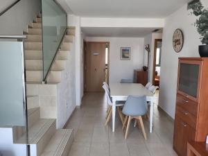 a kitchen and dining room with a table and a staircase at Roses Casc Antic SL Sabater 2 in Roses