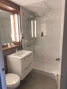 een badkamer met een douche, een toilet en een wastafel bij Brit Hotel Confort Nancy Lunéville in Lunéville