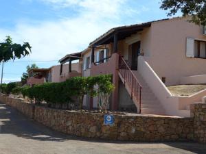 uma casa com uma parede de pedra ao lado de uma rua em Domaine San Sebastiano em Porto-Vecchio