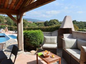 um pátio com um sofá, uma mesa e uma piscina em Domaine San Sebastiano em Porto-Vecchio