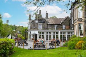 mensen aan tafels buiten een gebouw bij The Waterhead Inn- The Inn Collection Group in Ambleside