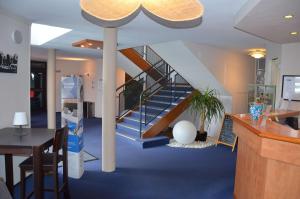 een lobby met een trap met een tafel en een bureau bij BRIT HOTEL Caen Hérouville in Hérouville-Saint-Clair