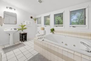 a white bathroom with a tub and a sink at Sunrise - 1322 Indian Point Road in Branson