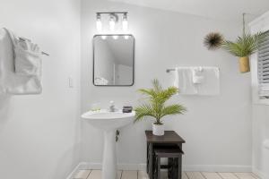 a white bathroom with a sink and a mirror at Sunrise - 1322 Indian Point Road in Branson