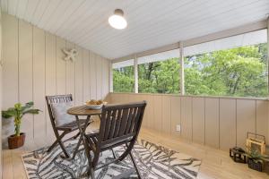 a screened in porch with two chairs and a table at Sunrise - 1322 Indian Point Road in Branson