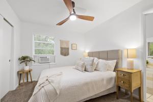 a white bedroom with a bed and a ceiling fan at Sunrise - 1322 Indian Point Road in Branson