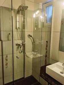 La salle de bains est pourvue d'une douche et d'un lavabo. dans l'établissement Exakt Holding, à Tulln