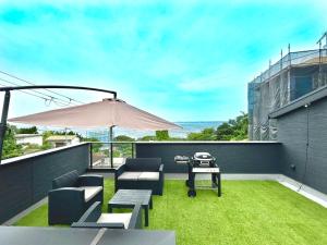 - une terrasse avec un barbecue, des chaises et un parasol dans l'établissement Keshiki 淡路島, à Awaji