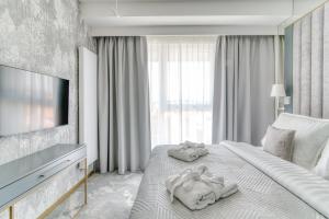 Apartamenty Premium N11 Mikołajki - Destigo Hotels في ميكووايكي: غرفة فندق عليها سرير وفوط