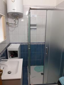 a bathroom with a shower and a sink at Comfortable apartment next to the beach in Durrës