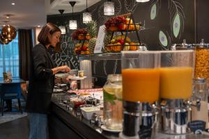 a woman preparing food at a counter in a restaurant at Boutique Hotel Germania in Munich