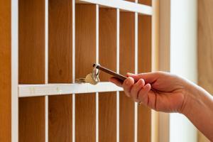 una persona sosteniendo una llave de una puerta en un estante de libros en Der Hechl, en Tauplitz