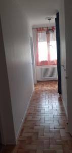 een hal met een raam en een tegelvloer bij appartement proche paris et Roissy in Persan