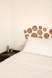 a bedroom with a white bed with a wooden headboard at Charme Room&Relax in Torre del Greco