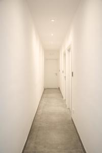 an empty corridor with white walls and a long hallway at Charme Room&Relax in Torre del Greco