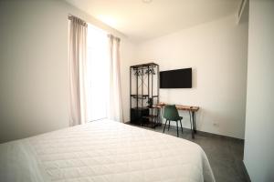 a bedroom with a bed and a desk and a television at Charme Room&Relax in Torre del Greco