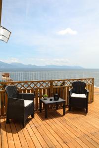 a deck with two chairs and a table and a view of the water at Charme Room&Relax in Torre del Greco