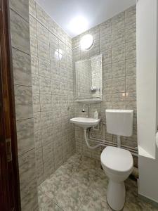 a bathroom with a toilet and a sink at B7 Apartament in Ocna-Mureşului