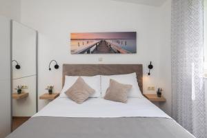 a bedroom with a bed and a painting on the wall at La Playa Beach Apartment in Omiš