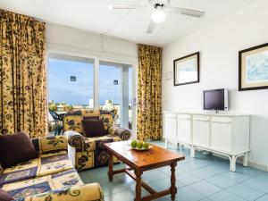 a living room with a couch and a tv at BelleVue Aquarius in Puerto del Carmen