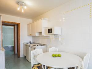 a white kitchen with a white table and chairs at BelleVue Aquarius in Puerto del Carmen