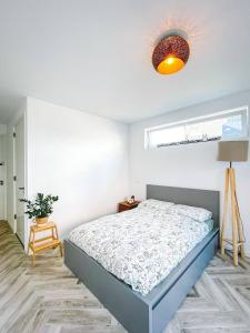 um quarto branco com uma cama e um candeeiro em Modern & Convenient Studio em Arnhem