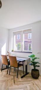 uma sala de jantar com uma mesa e cadeiras e uma janela em Modern & Convenient Studio em Arnhem