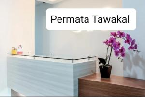 een bloem in een vaas zittend op een toonbank bij Guest House Permata Tawakal in Jakarta