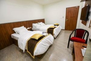 Giường trong phòng chung tại Naga Luxury Suites- Triple Bed Room --Driver Free Stay