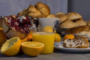 una mesa con un plato de pan y un vaso de zumo de naranja en Al Porto Di Lucca B&B, en Lucca